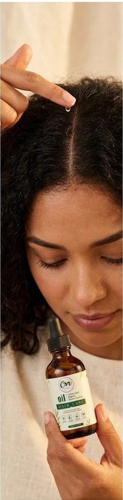 Applying a drop of OilNat Herbal Growth Oil to the scalp at the part line